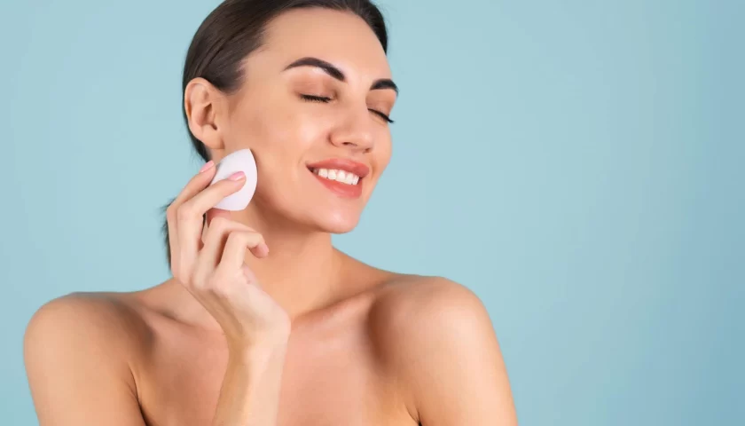 une femme avec un coton sur le visage pour illustrer le démaquillage